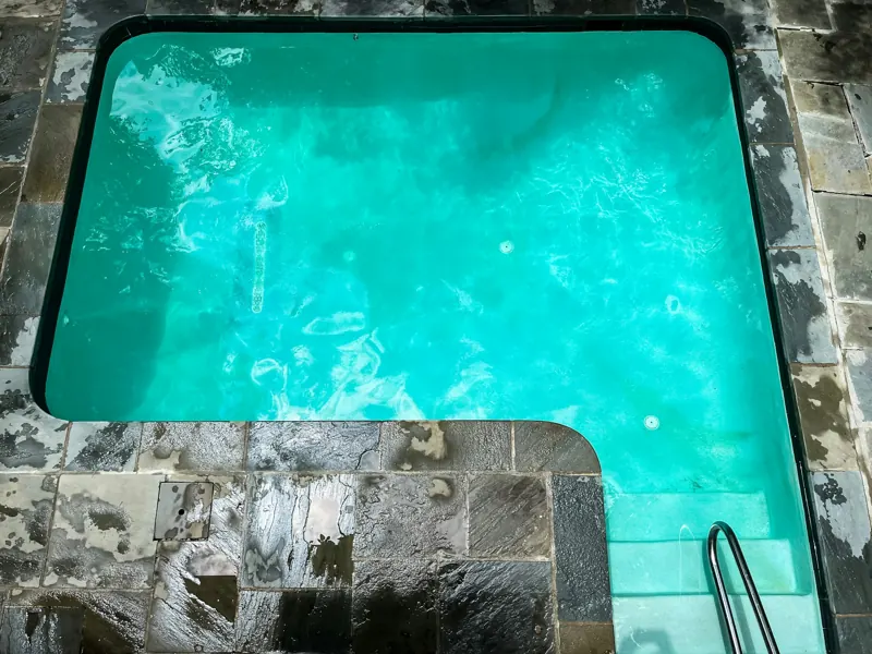 Example of a remodeled pool with stone coping and turquoise water